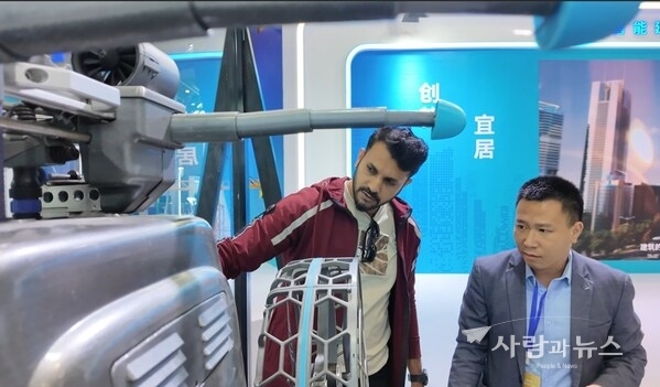 At an exhibition of the 2025 World Cities Day China Observance, a foreign visitor explored the robots and learned about their features and performance. (Photo/Luo Huxin)